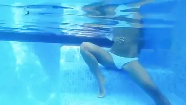 Модель мастурбирует под водой, сидя в бассейне