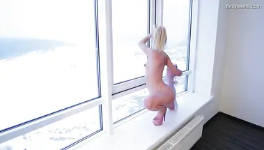 Российская гимнастка на стрипах садится на шпагат на подоконнике
